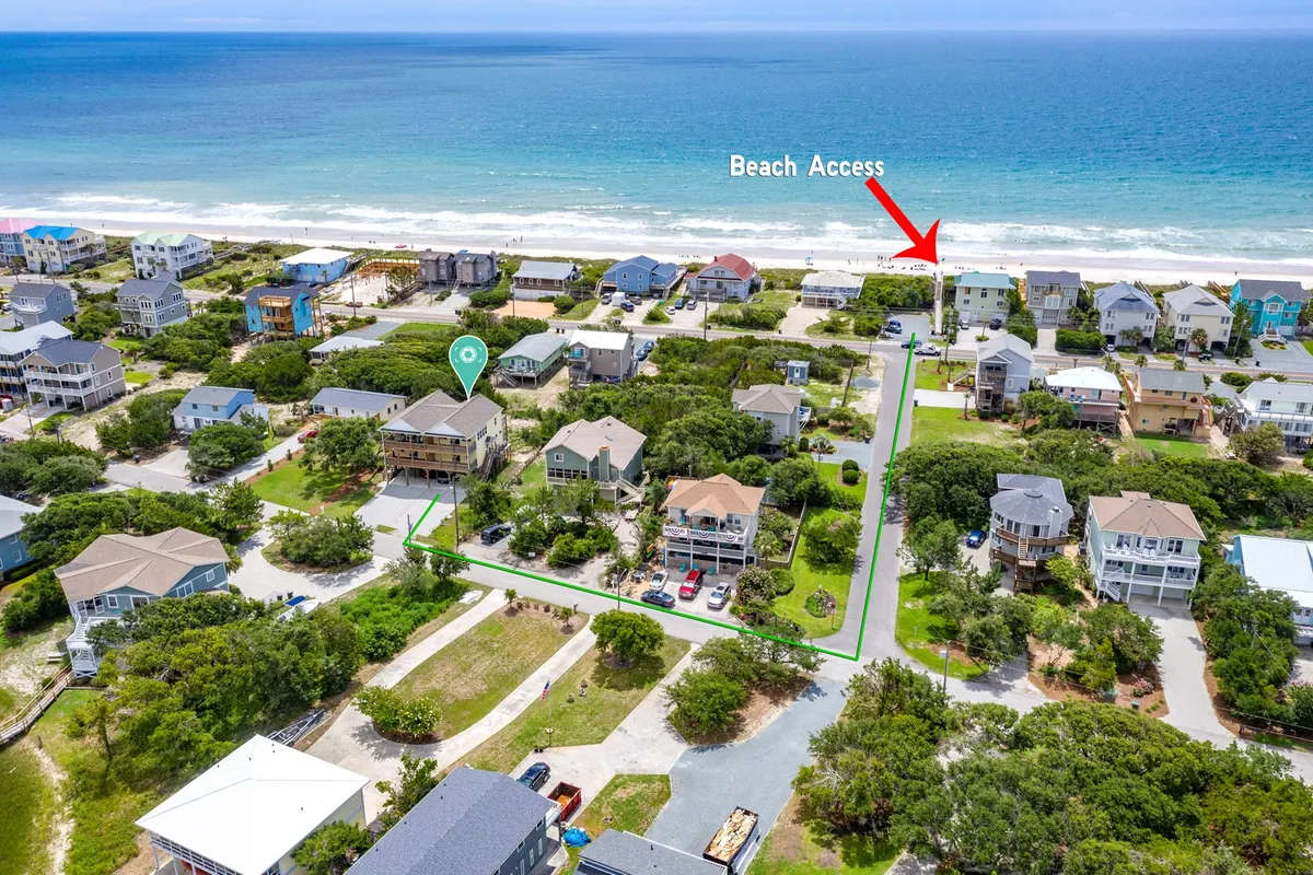 A scenic view of beach access paths, seaside homes, and greenery. The inviting walkway and vibrant setting evoke the ease of exploring the coast, beach outings, and local attractions just minutes from the home.